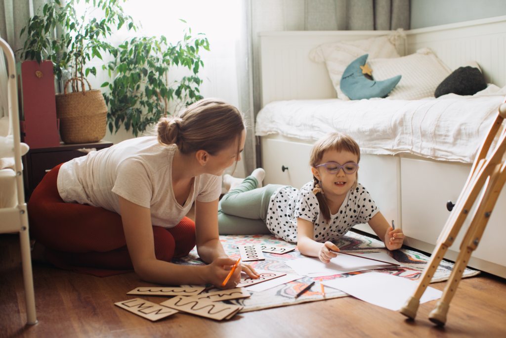 Enfant à besoins particuliers jouant à terre dans sa chambre avec ses parents